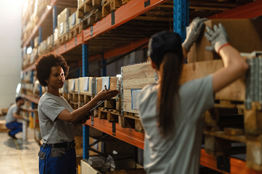 african american worker communicating with her female colleague while preparing shipment industrial warehouse 1